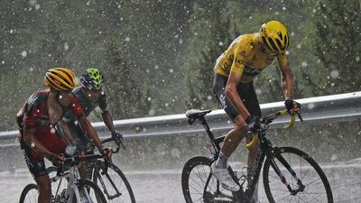 Britain’s Chris Froome, wearing the overall leader’s yellow jersey, Australia’s Richie Porte, left, and Colombia’s Nairo Quintana, second left, climb in pouring rain and hail towards Andorra Arcalis during the ninth stage of the Tour de France cycling race over 184.5km with start in Vielha Val d’Aran, Spain, and finish in Andorra Arcalis, Andorra, Sunday, July 10, 2016. Christophe Ena / AP Photo