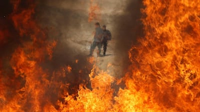 Afghan security forces in Kabul stand behind a burning pile of seized narcotics and alcohol. Omar Sobhani / Reuters