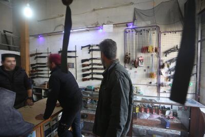 Customers buying ammunition at a gun shop in central Idlib. The National