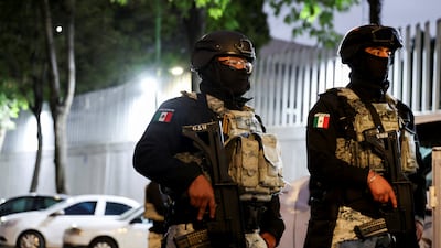 Members of the National Guard stand guard outside a building in Mexico City where the body of El Mencho is thought to be held. Reuters