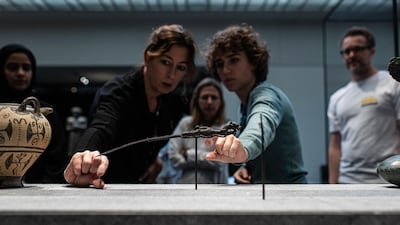 Noemi Dauce, left, curator of archaeology for Louvre Abu Dhabi, inspects the dagger as it goes on display. Courtesy Department of Culture and Tourism – Abu Dhabi