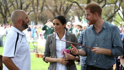 Prince Harry and Meghan are shown a boomerang during a visit to a community picnic at Victoria Park in Dubbo, Australia. AP