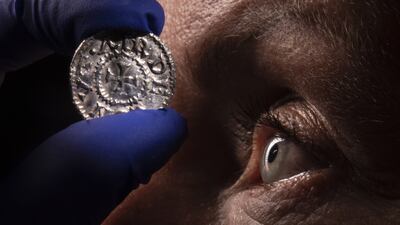 Jenny Truran, conservator at Lancashire County Museums Service, holds a penny from one of the largest Viking hoards discovered in the UK, ahead of a display at the Jorvik Viking Centre in York. PA