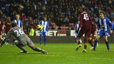 Manchester City striker Mario Balotelli scores from a rebound off Wigan goalkeeper Ali Al Habsi.