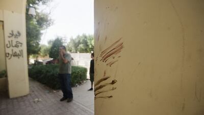 A Libyan man stands next to a wall apparently stained with blood at the main entrance of the US consulate in Benghazi on September 13, 2012. AFP