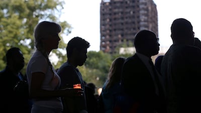 Candles are lit near to the burned-out Grenfell Tower during a silent march to pay respect to those killed in the disaster, on August 14, 2017. Jonathan Brady / PA via AP