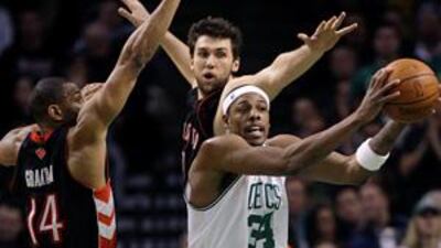 The Boston Celtics guard Paul Pierce passes off the ball as he is pressured by the Toronto Raptors' Andrea Bargnani, centre, and Joey Graham, left, during Monday's victory.