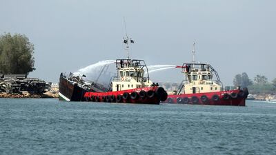 Firefighters tackle a fire on a boat in Sharjah's Khalid Port on Wednesday. Chris Whiteoak / The National