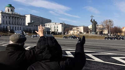 People wave at Mr Xi's motorcade driving towards the Kremlin. AP