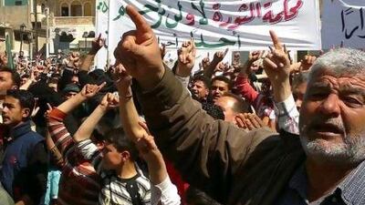 Anti-Syrian regime protesters shout slogans during a demonstration in Binish town in Idlib province on Monday. The Arabic banner in the background reads: "To who it may concern, the revolution's court will not forgive anyone".