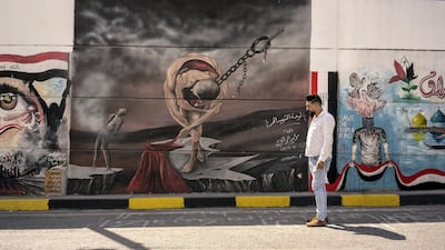Mustafa Abd standing next to the Painting of the free martyr in Al Sadoon tunnel next to Tahrir square. Haider Husseini for The National