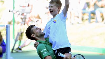 Novak Djokovic holds a Bosnian boy celebrating. AFP
