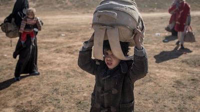 Civilians who have fled the fighting in Bagouz wait to board trucks after being screened by members of the Syrian Democratic Forces. Getty Images