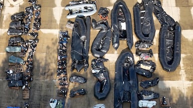 Small boats and outboard motors used by people smugglers at a warehouse in Dover, Kent. PA