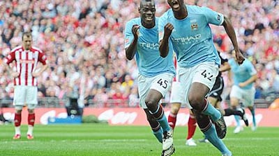 Yaya Toure of Manchester City, right, celebrates with Mario Balotelli after scoring the match-winner in the FA Cup final.