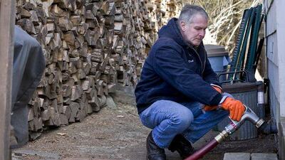Dick Balboni, of MacFarlane Oil, delivers heating oil to a suburban Boston home. Price stability is expected to last at least until April.