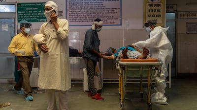 A man speaks on the phone as a doctor tries to revive his wife inside an emergency ward of a government-run hospital, amidst the coronavirus disease pandemic, in Bijnor district, Uttar Pradesh, India. Reuters