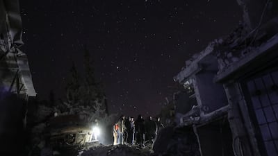 Civilians use their mobile phones as a torches as they and civil defence volunteers look for survivors in the rubble of a building in Douma that was hit by Syrian government bombing on February 6, 2018. Mohammed Badra / EPA
