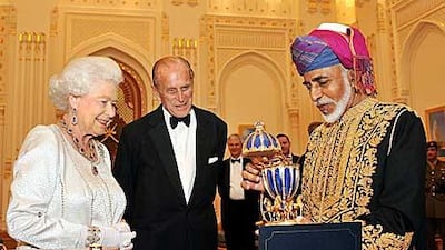 The Sultan of Oman, Sultan Qaboos bin Said, presents Britain’s Queen Elizabeth II with a gold musical Faberge style egg as Prince Philip watches on at the royal palace in Oman.