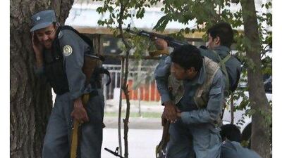 Afghan policemen fire towards a building taken over by Taliban insurgents during an attack near the US embassy in Kabul yesterday. Ahmad Masood / Reuters