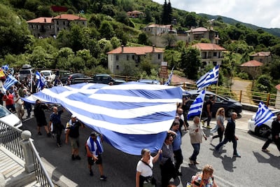Protesters carry a Greek flag during a demonstration against the agreement reached by Greece and Macedonia to resolve a dispute over the former Yugoslav republic's name, in Pisoderi village, northern Greece on June 17, 2018. Alexandros Avramidis / Reuters