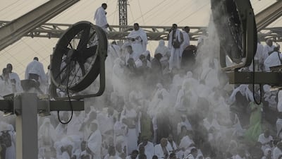 Cooling fans spray water over Muslim pilgrims on Mount Arafat. AP
