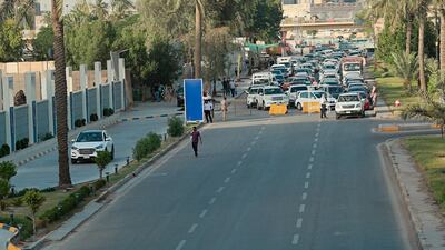 Security forces close a street during a curfew to help prevent the spread of the coronavirus, in downtown, Baghdad, Iraq. AP