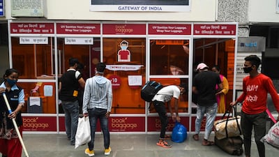 Passengers sanitise their baggage using a UV disinfection machine at a railway terminal in Mumbai, India, on April 7, 2021. AFP