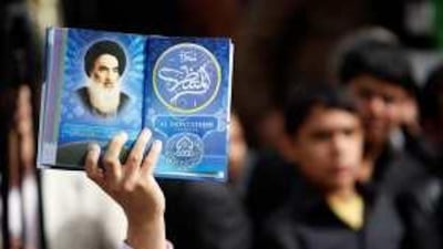 An Iraqi man holds a picture of the top Shiite cleric Grand Ayatollah Ali Sistani at a campaign rally.