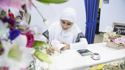 Aysha Al Naqbi signs copies of her novel Blue Moon at the Abu Dhabi International Book Fair. Antonie Robertson / The National