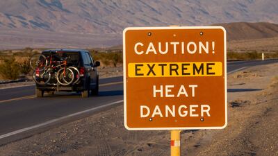 A car passes a sign warning of extreme heat in Death Valley National Park, California. AFP
