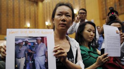 Kelly, the wife of a passenger aboard missing Malaysia Airlines Flight MH370, shows a picture yesterday of her husband walking with Malaysian prime minister Najib Razak, in Putrajaya. Olivia Harris / Reuters