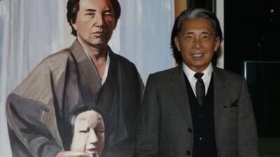 Fashion designer Kenzo Takada posing next to his self-portrait painting during the Monaco Fight Aids Gala, in Monaco, on December 1, 2014. AFP