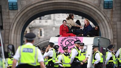 Police officers stand near Extinction Rebellion environmental movement protesters demonstrating on Tower Bridge. EPA