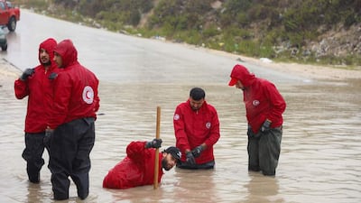Members of the Libyan Red Crescent work on opening roads engulfed in floods at an undefined location in eastern Libya. AFP