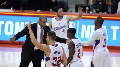 Los Angeles Clippers coach Doc Rivers celebrates with players (front, left to right) Blake Griffin (32), Darren Collison (2), JJ Redick (4) and Chris Paul (30) at the end of their win over the Golden State Warriors on Tuesday night. Robyn Beck / AFP / April 29, 2014