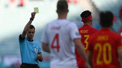 Referee Clement Turpin shows yellow card to Wales' midfielder Kieffer Moore. AFP