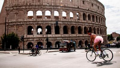 A man wearing a pink tutu rides a bicycle past the Coliseum monument as he takes part in a "Rome Pride LGBTI" flashmob in Rome, as the country eases its lockdown. AFP
