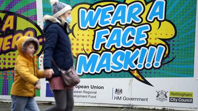 A sign urging residents to wear face masks in Nottingham. People who have tested positive for the coronavirus will now be able to leave home on day seven if they have two negative tests. AP