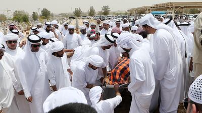 Friends and family members attend the burial of Khaled Qai at the Al Qusais Cemetery in Dubai. Pawan Singh / The National