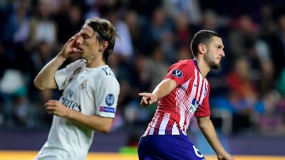 Real's Luka Modric, left, reacts as Atletico's Koke celebrates after scoring his team's fourth goal. AFP