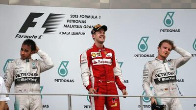 Lewis Hamilton and Nico Rosberg of Mercedes react as Sebastian Vettel of Ferrari celebrates after winning the Malaysian Grand Prix. Vincent Thian / AP / March 29, 2015