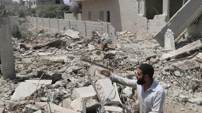 A man inspects a site hit by what activists say was a barrel bomb dropped by forces loyal to President Bashar Al Assad in Saida village in the eastern countryside of Deraa province on May 11, 2014. Mohamed Fares / Reuters