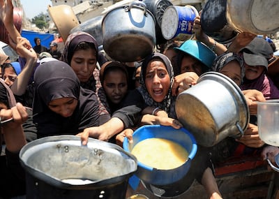 Palestinians gather to receive food from a charity kitchen in Gaza city. Reuters