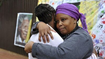 Two women console each other on Vilakazi Street in Soweto, where former South African President Nelson Mandela resided when he lived in the township. Mandela's death is being mourned in South Africa and around the world. Ihsaan Haffejee / Reuters