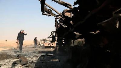 Syrian rebels inspect what's left of a government convoy following clashes in the outskirts of the northern city of Raqqa.
