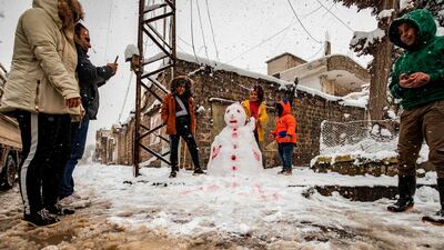 Children build a snowman together in the northeastern Syrian town of al-Malikiyah (Derik) at the border with Turkey after a blizzard. AFP