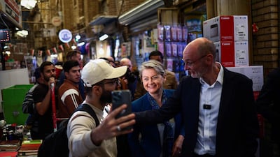 Ms Cooper and Britain's Ambassador to Iraq Stephen Hitchen meet members of the public as they visit the book market in Baghdad's Al Mutanabbi Street