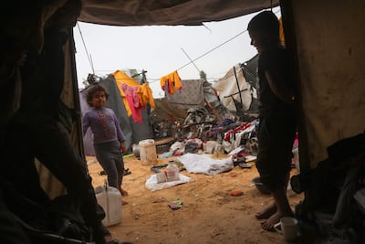 Children stand outside a tent at a makeshift camp for displaced Palestinians in the Nahr Al Bared area in Khan Younis in the southern Gaza Strip on April 1, 2026. AFP