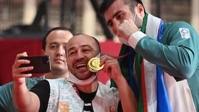 Uzbekistan gold medallist Bakhodir Jalolov poses with fans after the victory ceremony for the men's super heavy (over 91kg) boxing final bout during the Tokyo 2020 Olympic Games at the Kokugikan Arena in Tokyo.